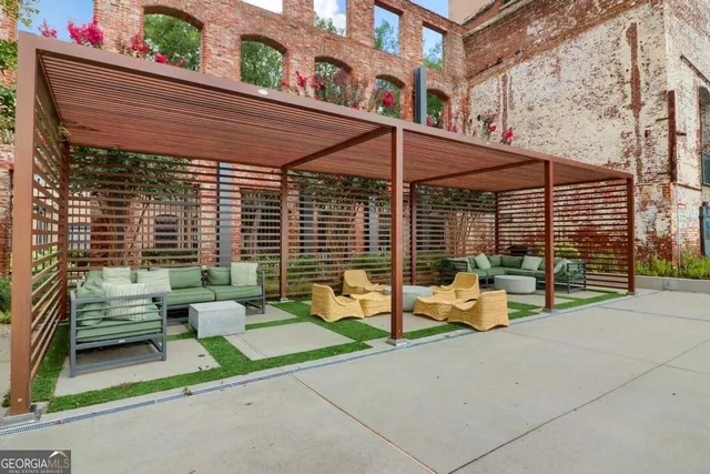 a view of a patio with couches and chairs under an umbrella