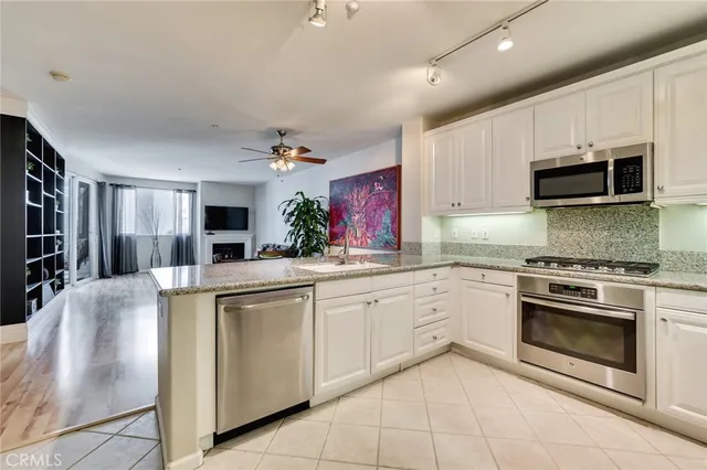 a kitchen with stainless steel appliances granite countertop a refrigerator sink stove and microwave