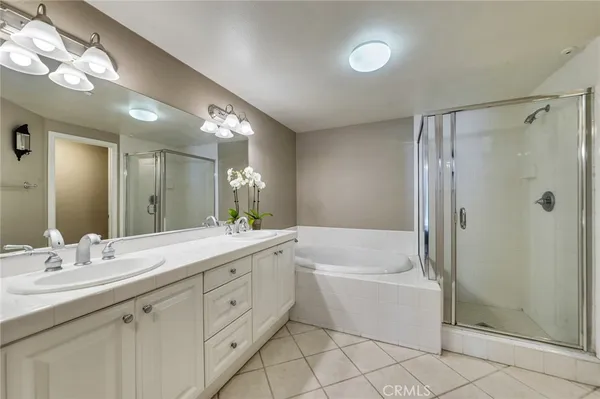 a bathroom with a double vanity sink mirror and bathtub
