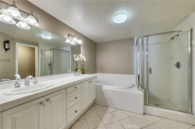a bathroom with a double vanity sink mirror and bathtub