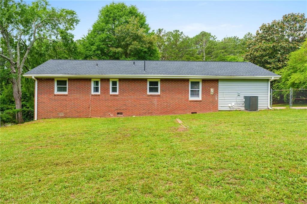 1745 Rockbridge Road Northwest Conyers, GA 30012 - Photo 24 of 32 a front view of house with yard and trees in the background