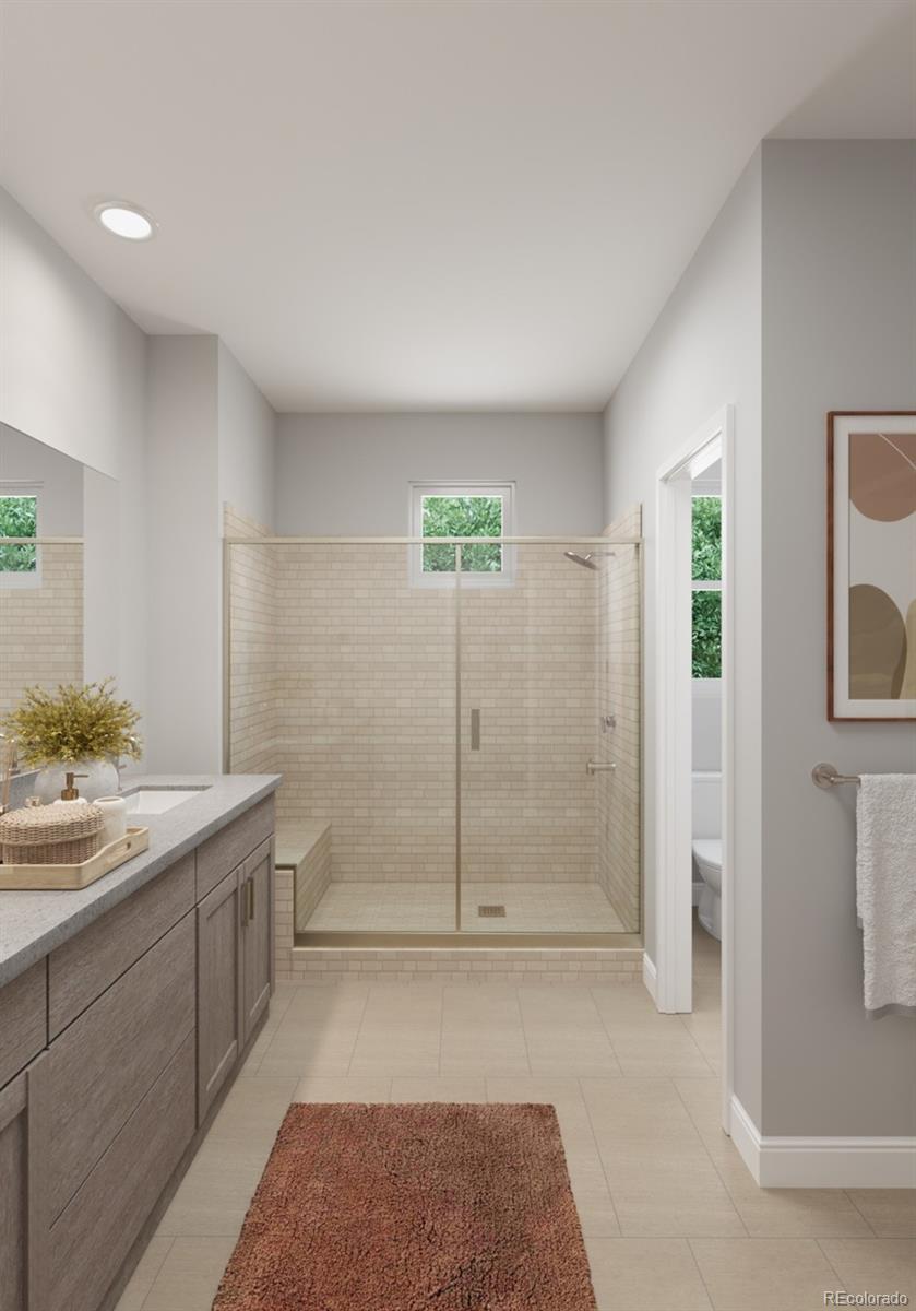 9173 Violet Way Arvada, CO 80007 - Photo 19 of 32 a spacious bathroom with a granite countertop sink a toilet and shower