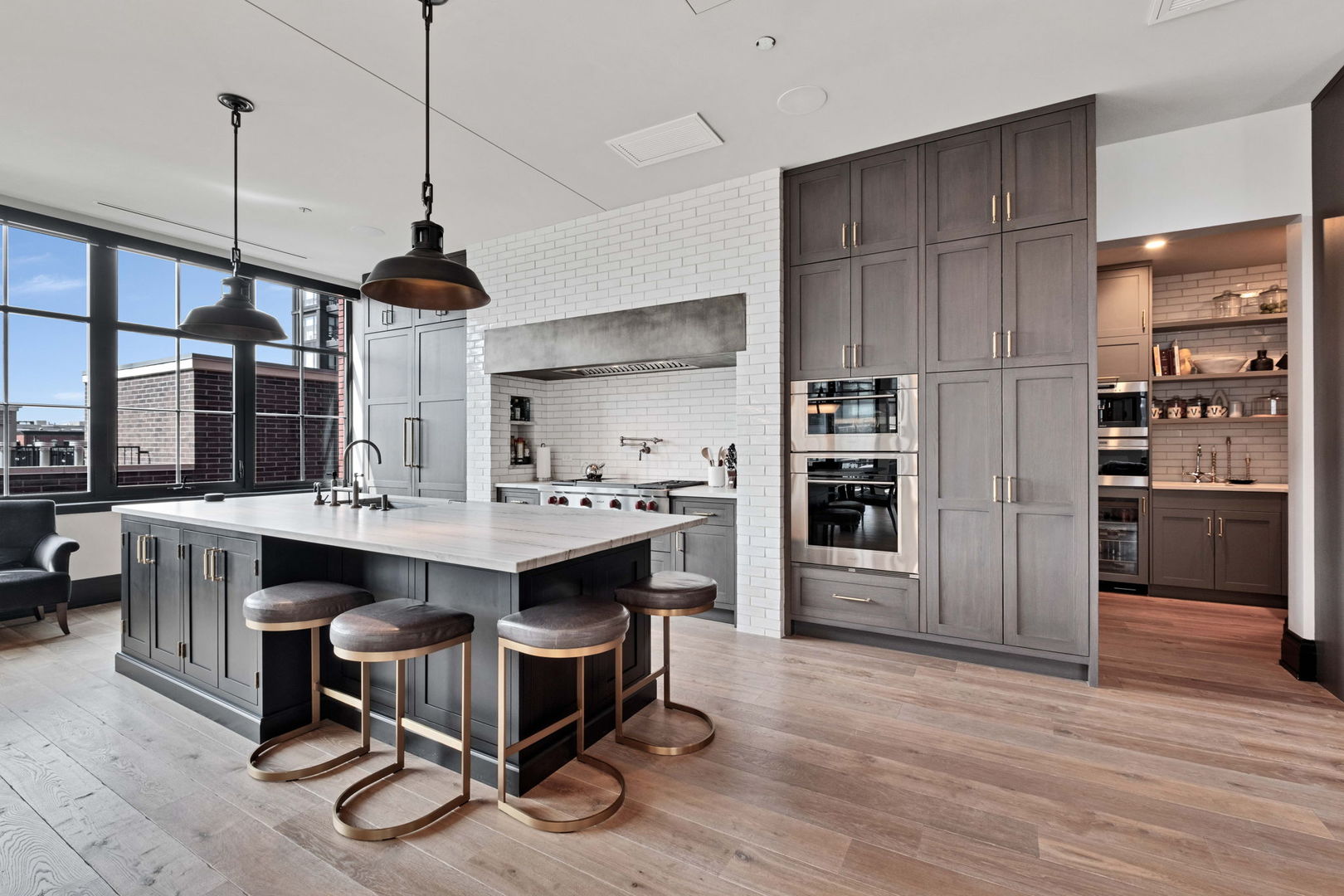 1109 West Washington Boulevard, Unit 5C Chicago, IL 60607 - Photo 13 of 31 a kitchen with kitchen island a wooden floor and a refrigerator