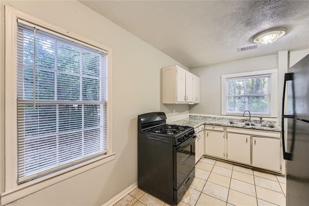 2275 Old Spring Road Smyrna, GA 30080 - Photo 12 of 28 a kitchen with stainless steel appliances granite countertop a stove a sink and a refrigerator