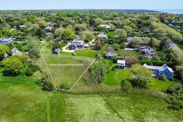an aerial view of residential houses with outdoor space and trees