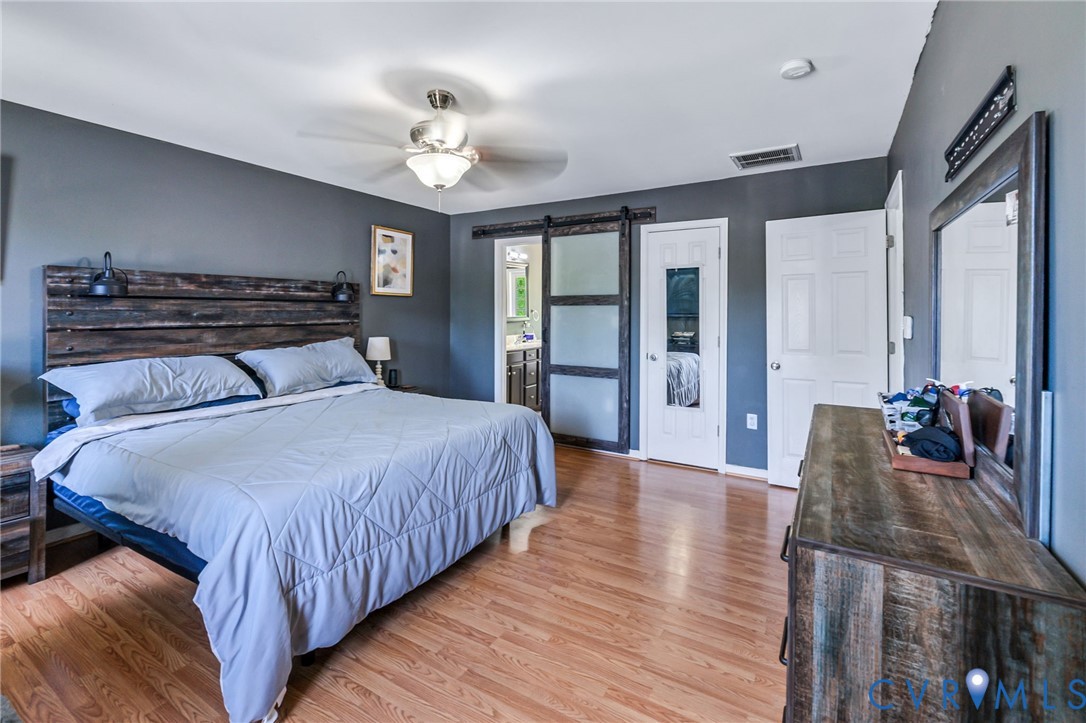 3218 Rimswell Court Midlothian, VA 23112 - Photo 27 of 32 Bedroom featuring a barn door, light wood finished