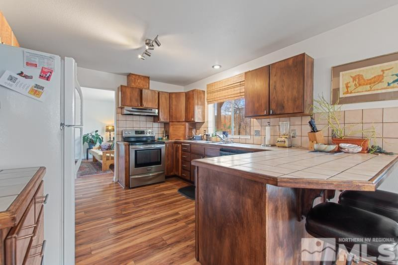 3920 West 7th Street Reno, NV 89503 - Photo 7 of 20 a kitchen with kitchen island a stove a sink and a refrigerator