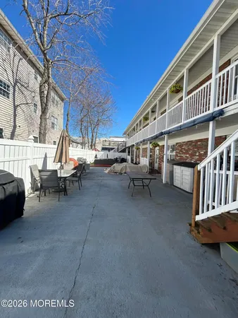a view of a patio with couches and table and chairs and wooden fence
