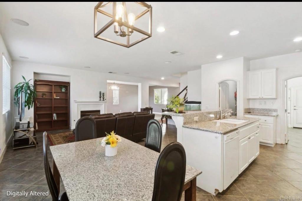 1234 Old Janal Ranch Road Chula Vista, CA 91915 - Photo 14 of 34 a kitchen with stainless steel appliances granite countertop a stove top oven a dining table and chairs with wooden floor