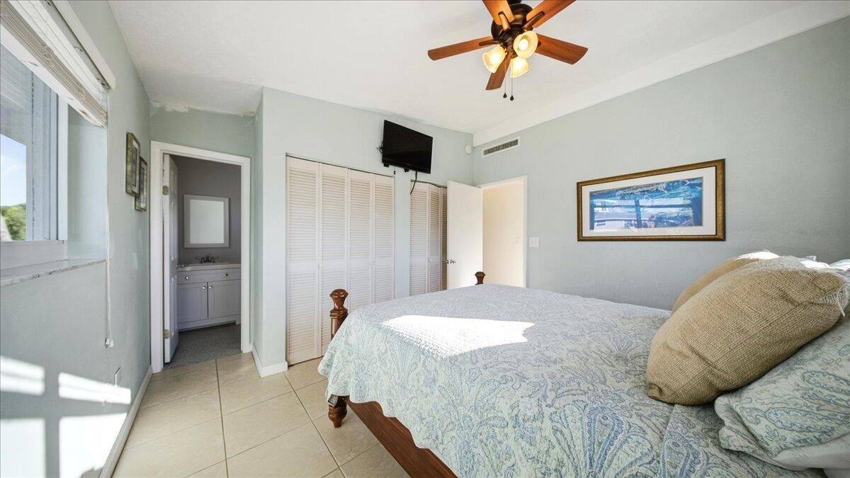 203 Bessie Road Tavernier, FL 33070 - Photo 31 of 42 a bedroom with a bed and a chandelier