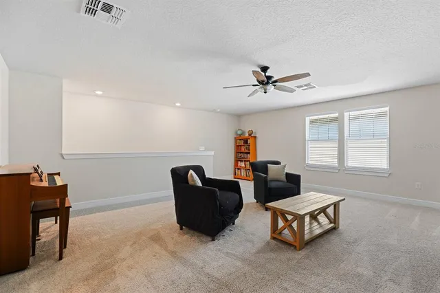 a living room with furniture and a ceiling fan
