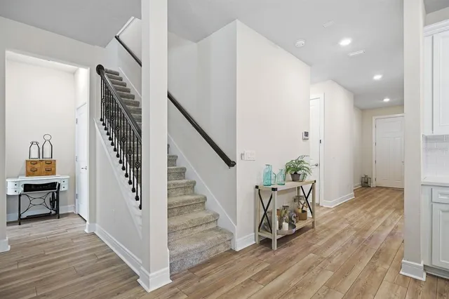 a view of a hallway with wooden floor stairs and a livingroom view