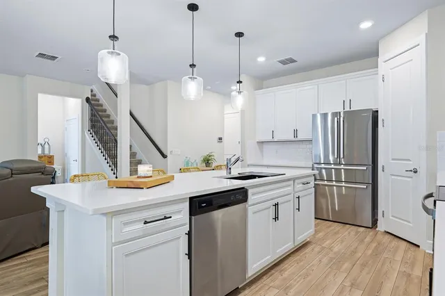 a kitchen with a sink a counter space appliances and cabinets