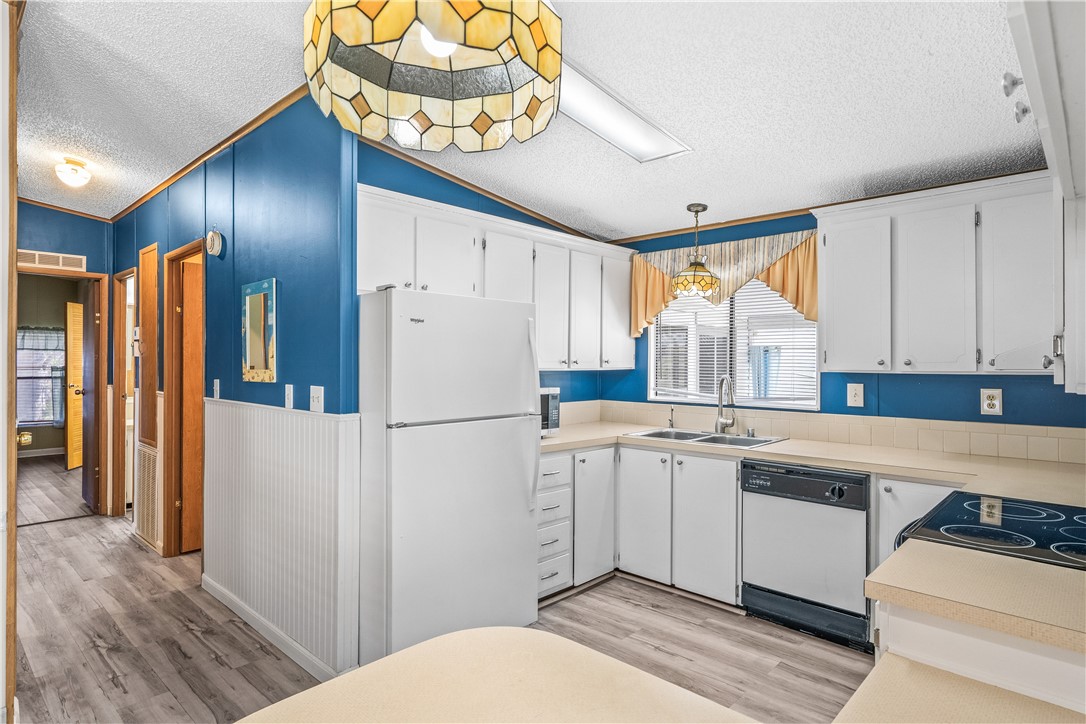 7635 Blackhawk Road Micco, FL 32976 - Photo 11 of 30 a kitchen with a refrigerator a sink and cabinets