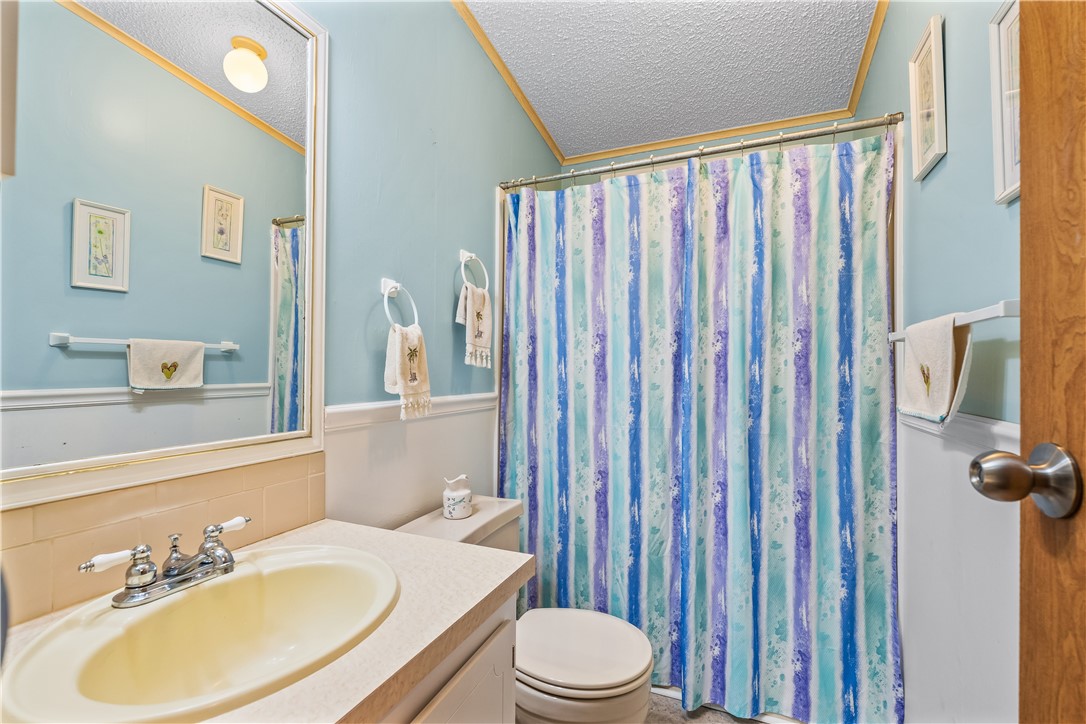 7635 Blackhawk Road Micco, FL 32976 - Photo 17 of 30 a bathroom with a sink a toilet and shower curtain