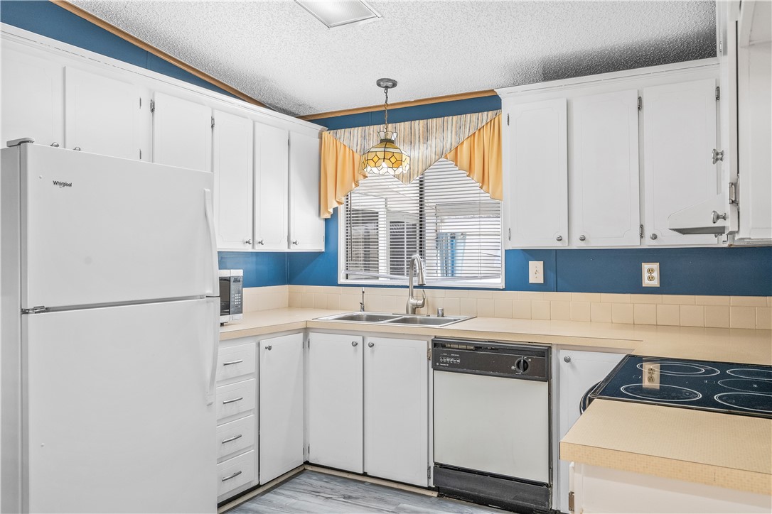 7635 Blackhawk Road Micco, FL 32976 - Photo 4 of 30 a kitchen with white cabinets and white appliances