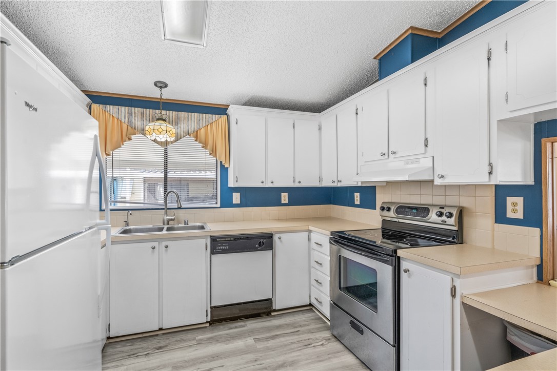 7635 Blackhawk Road Micco, FL 32976 - Photo 10 of 30 a kitchen with granite countertop white cabinets and white appliances