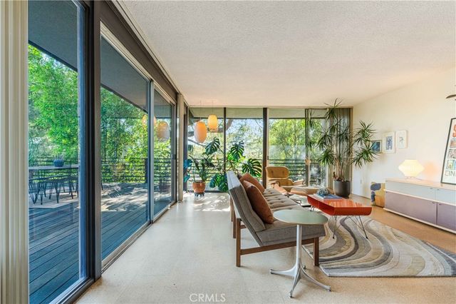 a dining room with furniture and a floor to ceiling window