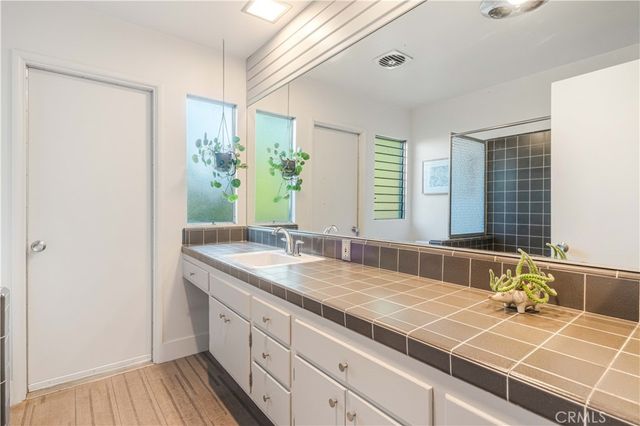 a bathroom with a granite countertop sink and a large mirror