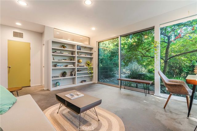 a living room with furniture a large window and a flat screen tv