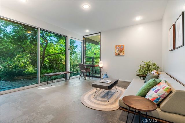 a living room with furniture and a floor to ceiling window