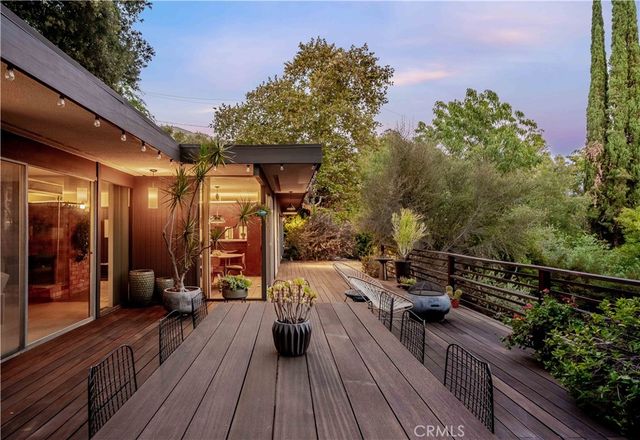 a view of a balcony with wooden floor and outdoor seating
