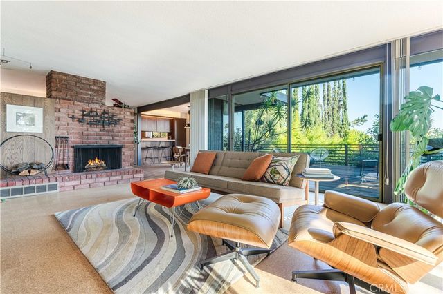 a living room with furniture large window and a fireplace