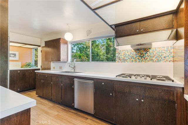 a kitchen with a sink a window and cabinets