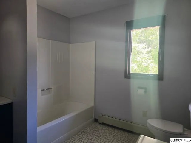 a bathroom with a bathtub toilet and window