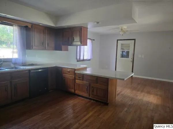 a kitchen with stainless steel appliances granite countertop a sink cabinets and wooden floor
