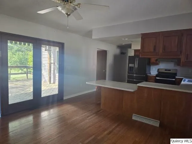 a kitchen with kitchen island granite countertop a sink cabinets and wooden floor