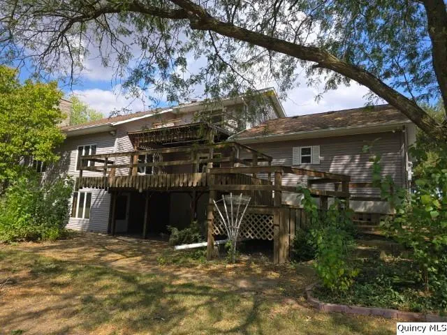 a view of a house with a tree and wooden fence