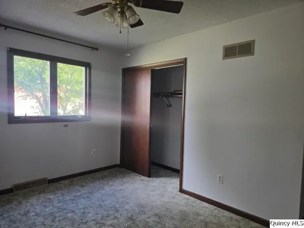 an empty room with windows and closet