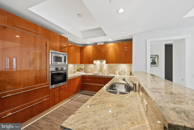 a view of a kitchen with stainless steel appliances granite countertop a sink and cabinets