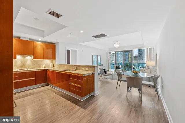 a large living room with stainless steel appliances granite countertop a stove and wooden floor