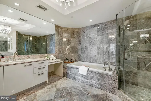 a bathroom with a granite countertop sink a toilet a mirror and shower