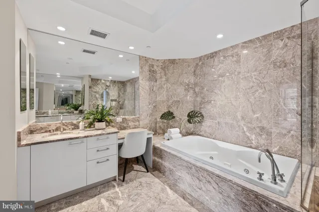 a bathroom with a granite countertop sink a toilet and bathtub