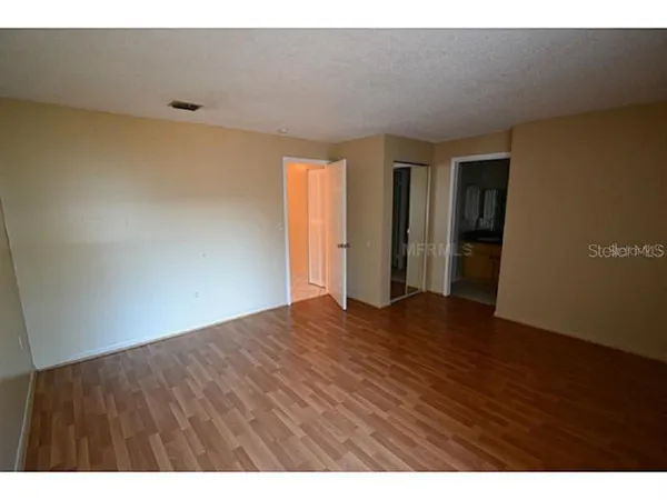 a view of an empty room with wooden floor