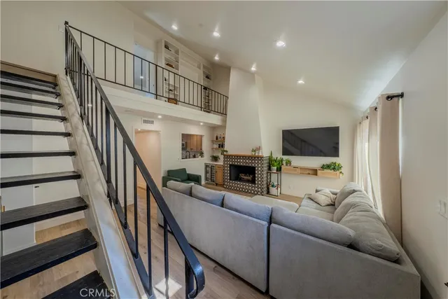a living room with furniture flat screen tv and a chandelier