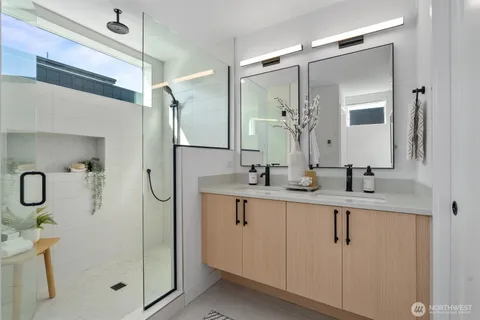 a bathroom with a double vanity sink mirror and shower
