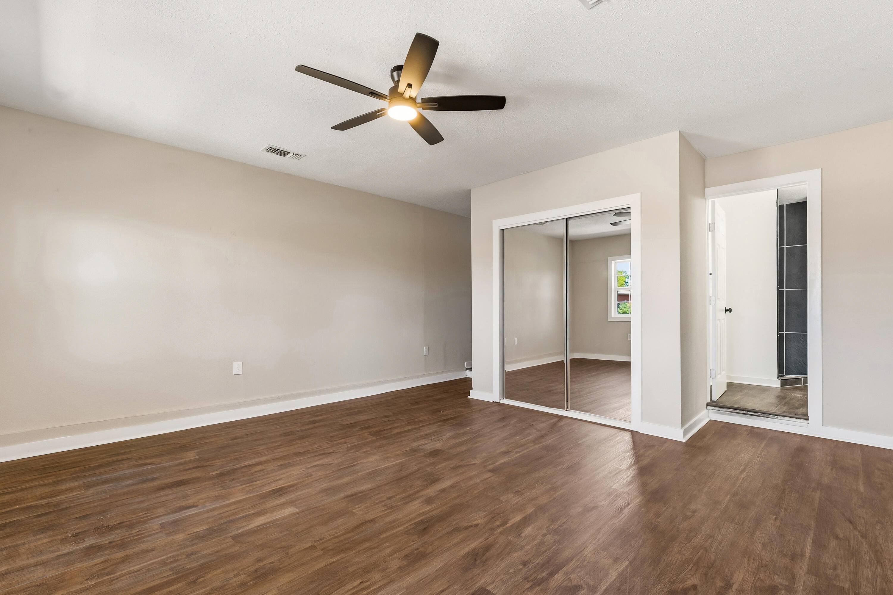 5015 16th Street Lubbock, TX 79416 - Photo 11 of 27 an empty room with wooden floor and a ceiling fan