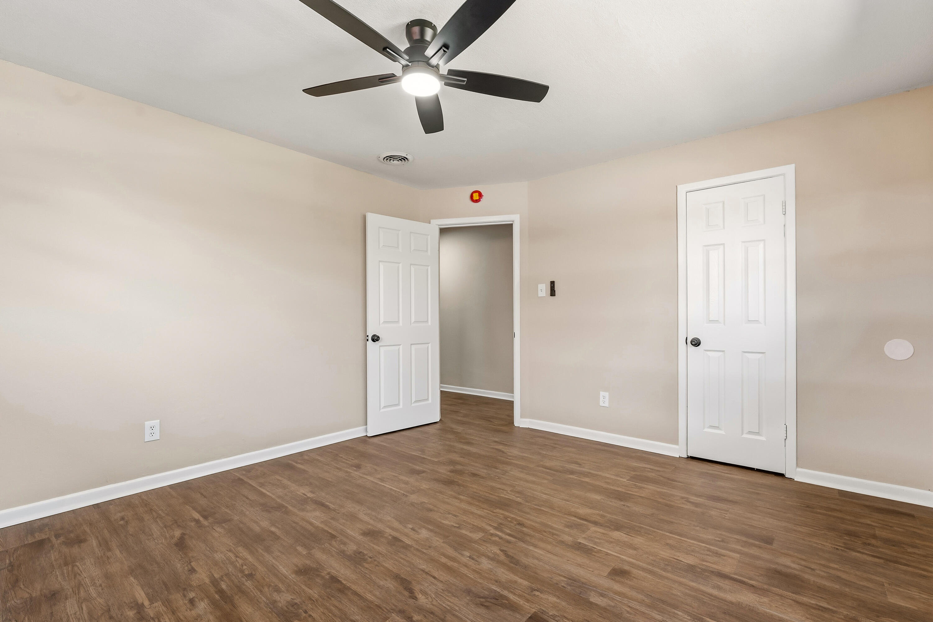 5015 16th Street Lubbock, TX 79416 - Photo 14 of 27 an empty room with wooden floor ceiling fan and windows