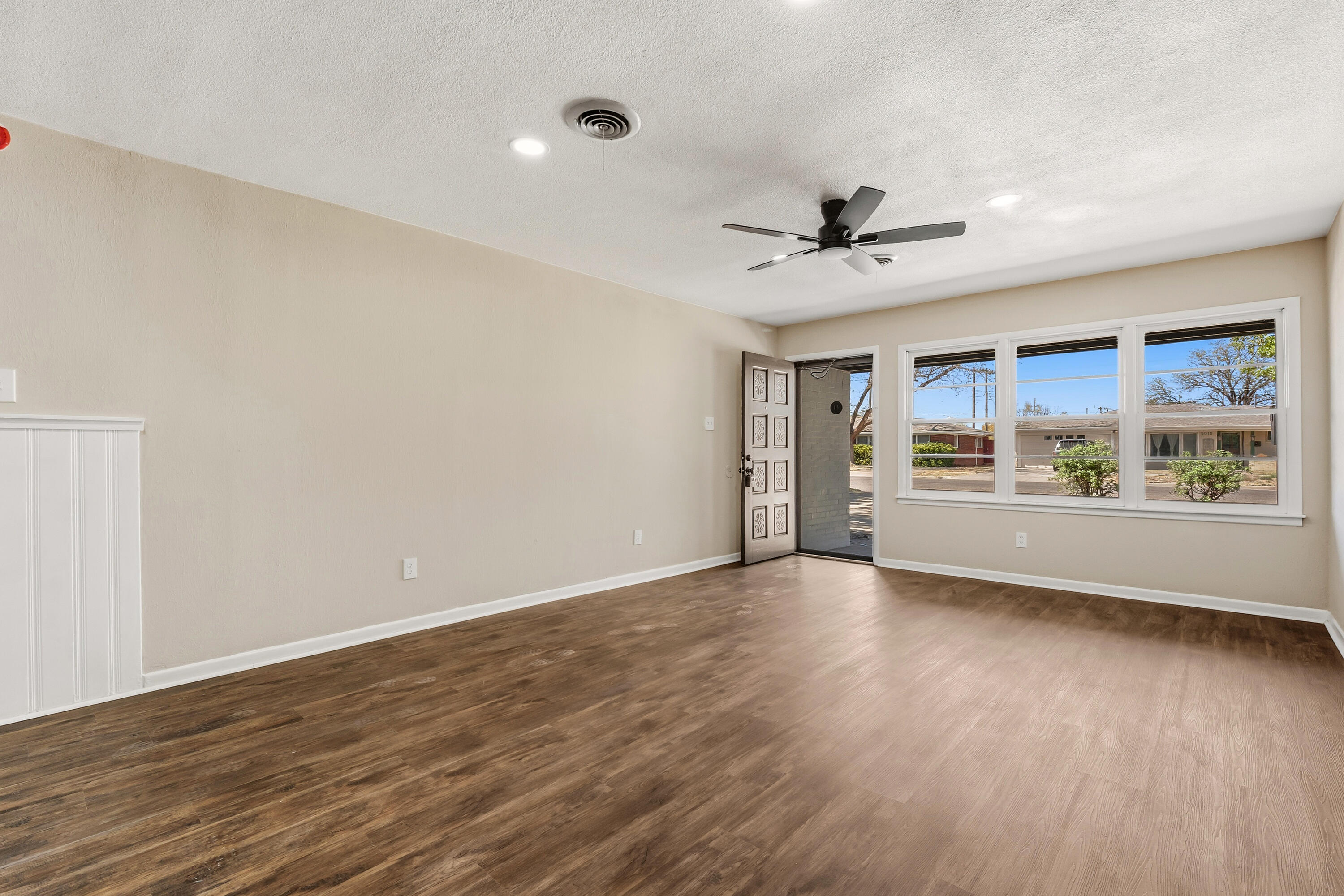 5015 16th Street Lubbock, TX 79416 - Photo 6 of 27 a view of an empty room with a window and wooden floor