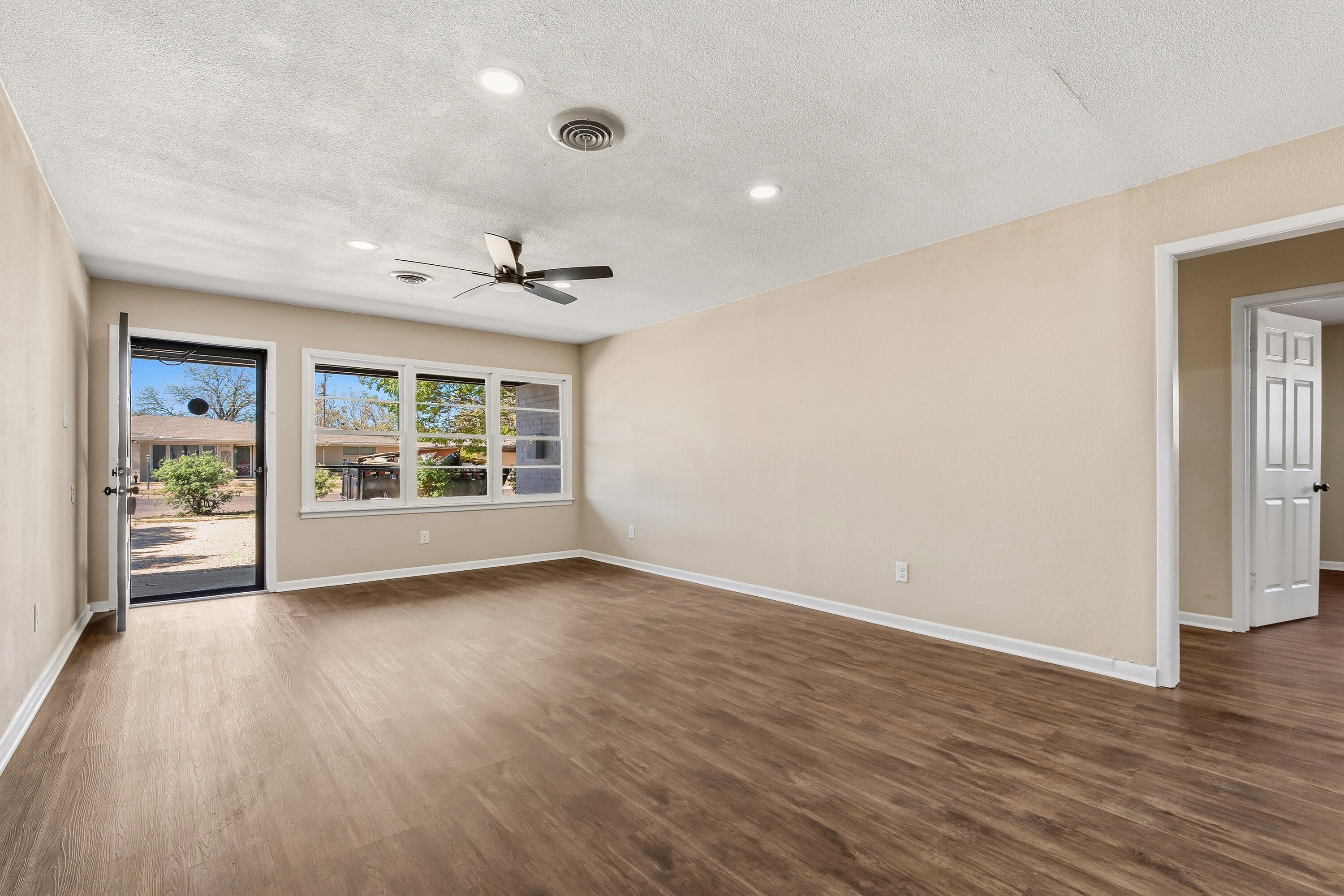 5015 16th Street Lubbock, TX 79416 - Photo 7 of 27 a view of an empty room with a window and wooden floor