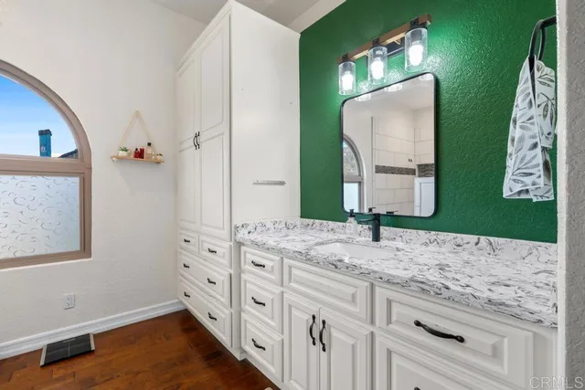 a bathroom with a granite countertop sink mirror vanity and toilet