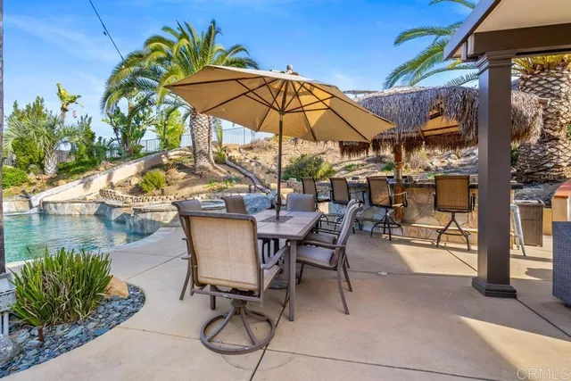 a patio with a table and chairs under an umbrella