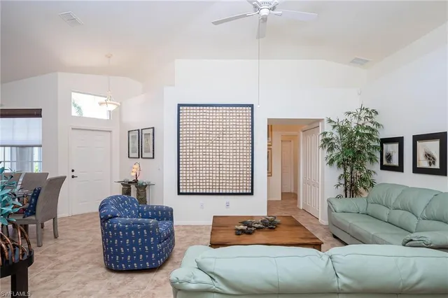 a living room with furniture a couch and potted plants