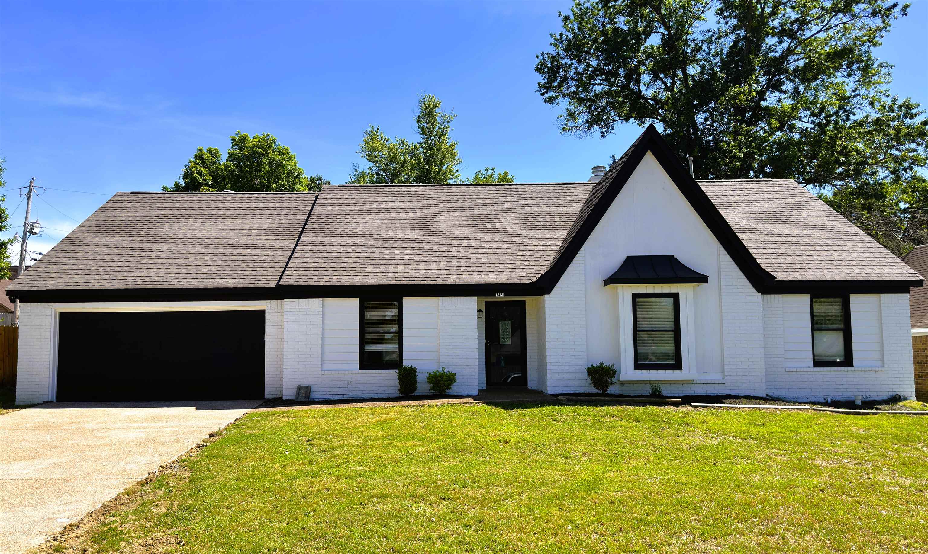 7421 Richmond Road Memphis, TN 38125 - Photo 2 of 39 White brick exterior with a dark shingle roof and contrasting black trim