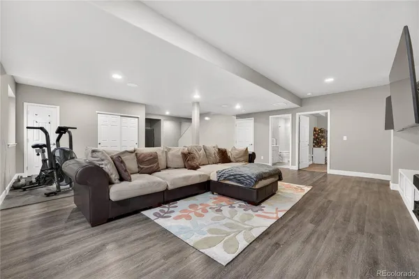 a living room with furniture and a wooden floor