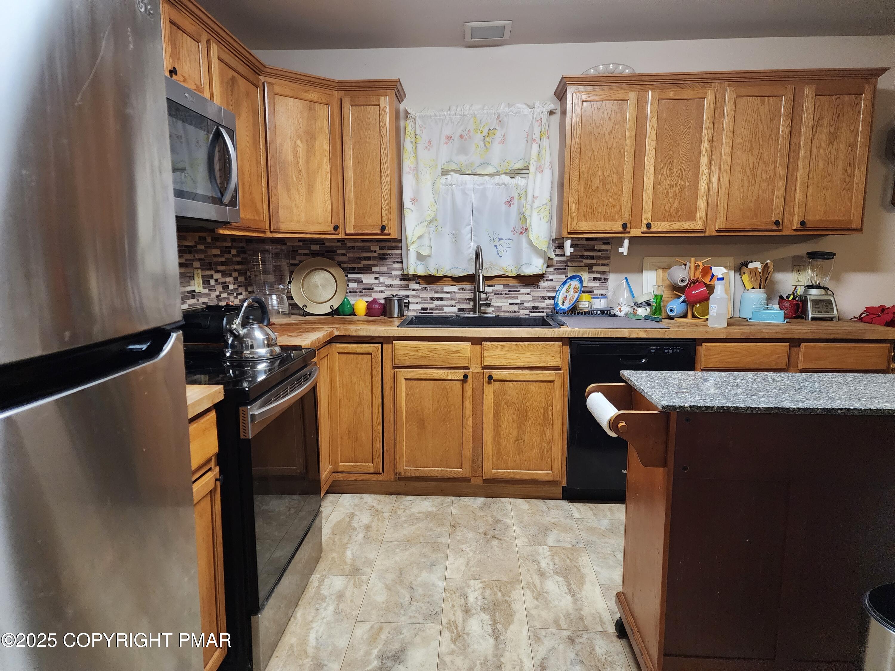 195 Williams Lane Scotrun, PA 18355 - Photo 8 of 17 a kitchen with stainless steel appliances granite countertop a sink stove and refrigerator